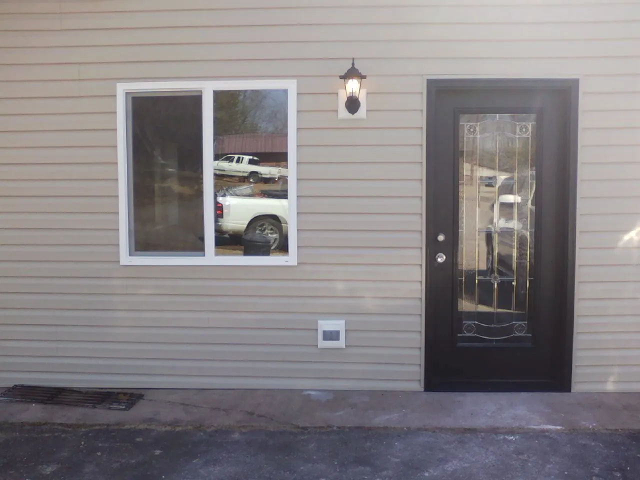 New siding, window and entry door on the side of an addition in Crawford