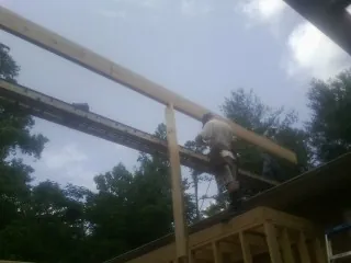 Carpenter setting a ridge beam over a new addition frame — Ice Dam Removal by Roofing Brothers in Crawford