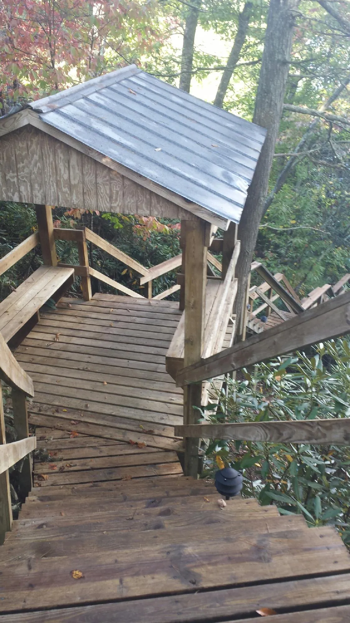 Metal roofed shelter over wooden steps on a wooded walkway — Skylight Repair & Installation work by our crew in Crawford
